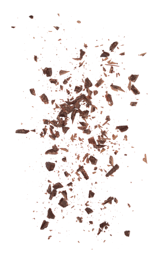 Trozos de chocolate oscuro en diferentes tamaños, esparcidos sobre un fondo blanco, ideales para repostería y decoración de postres.