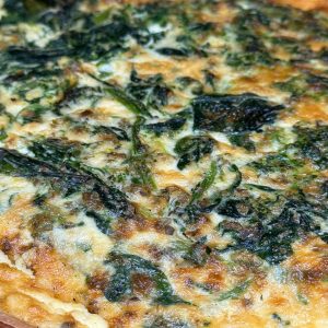 Pizza de espinacas recién horneada con una base crujiente y cubierta de queso dorado y espinacas frescas. Ideal para una comida saludable y deliciosa.